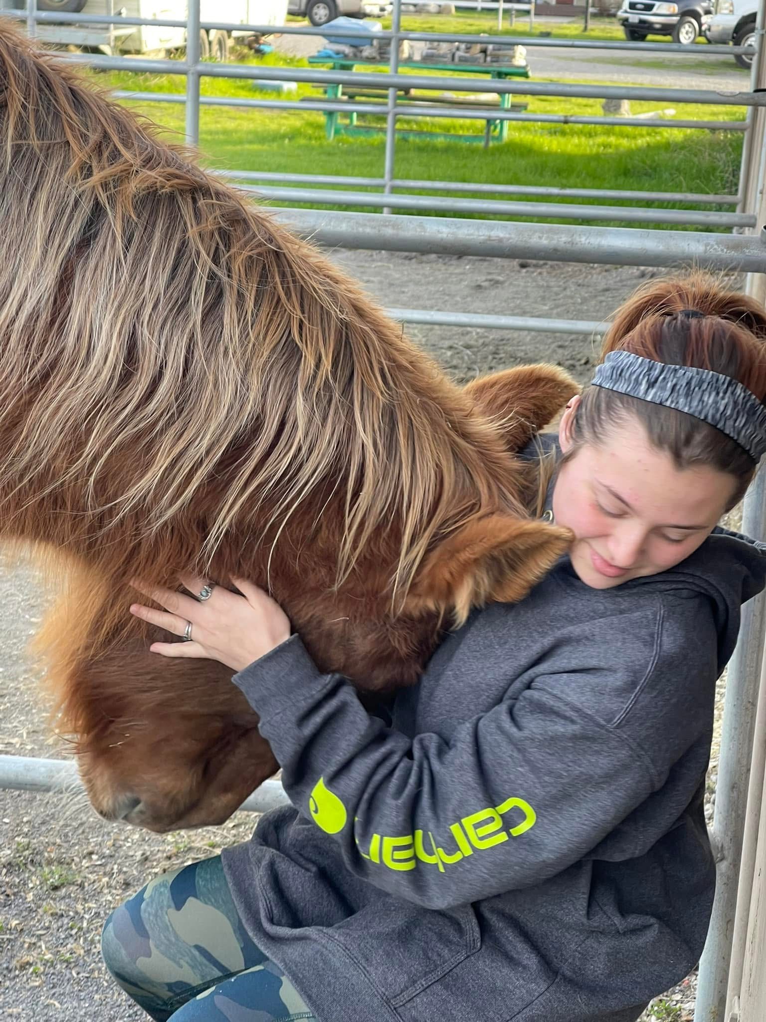 A child resting against a horse in a quiet, calm moment of connection
